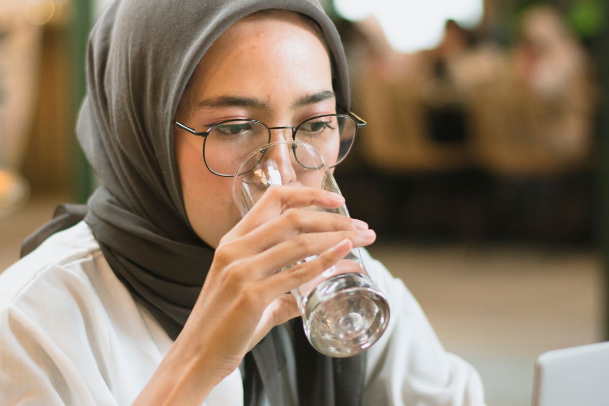 Wanita sedang minum air mineral