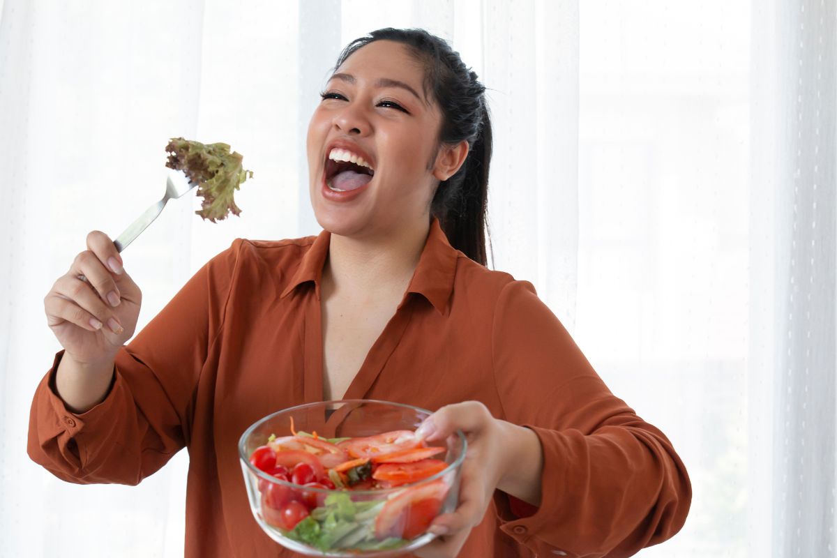 Seorang wanita sedang memakan makanan yang sehat