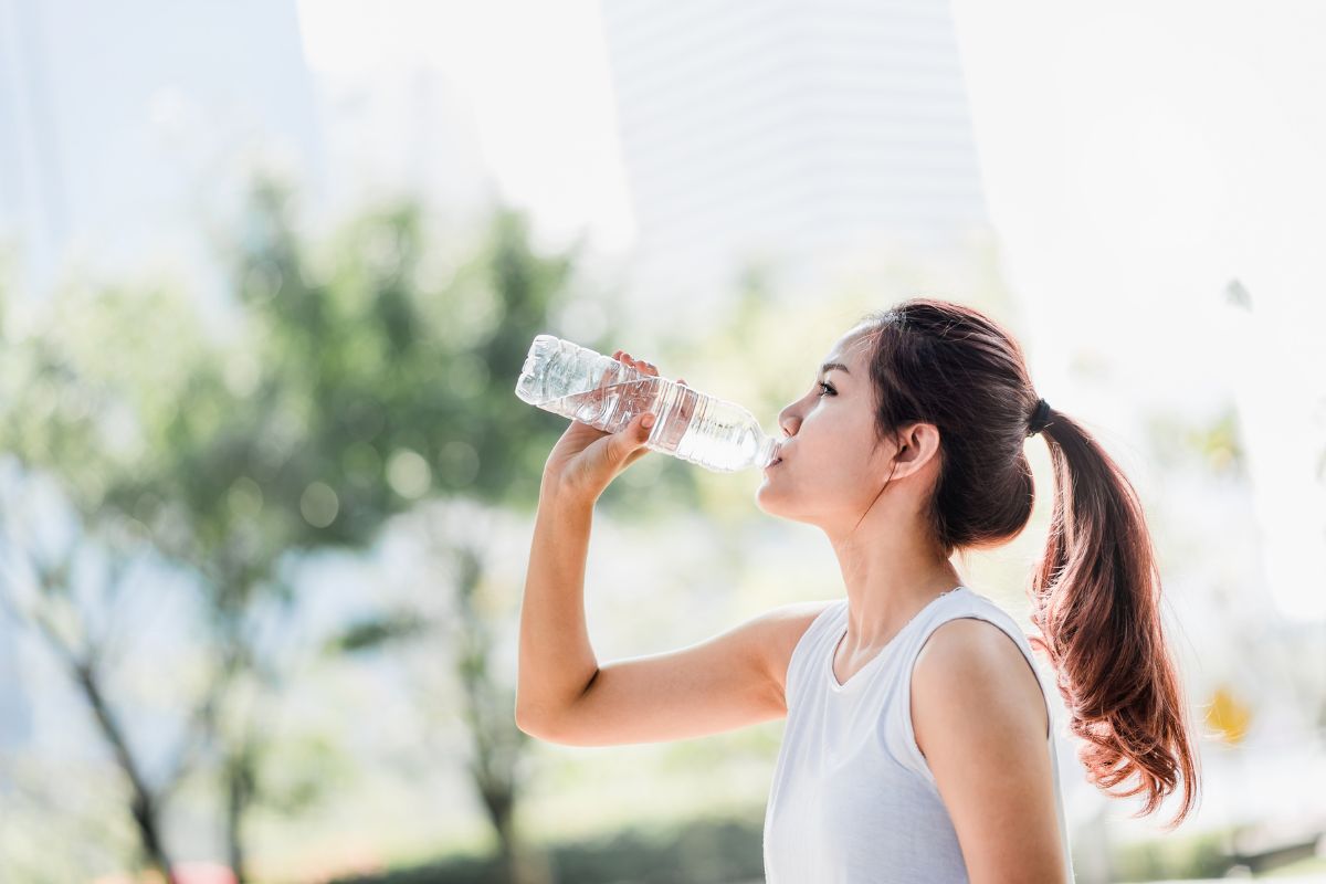 Wanita sedang meminum air mineral