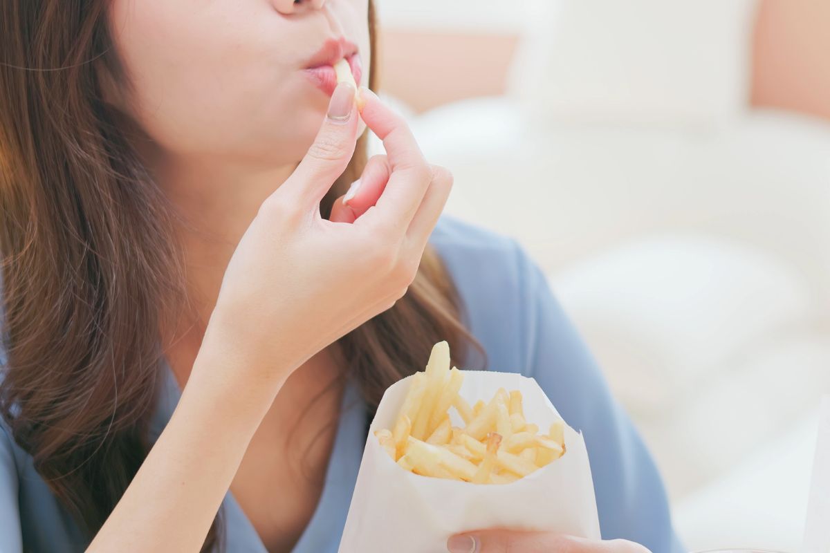 Wanita memakan kentang goreng