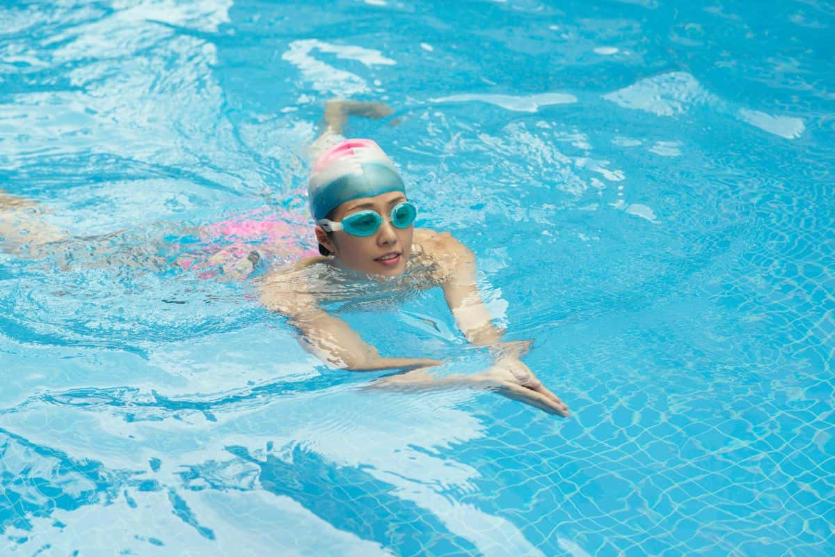 Seorang wanita sedang berenang di kolam renang