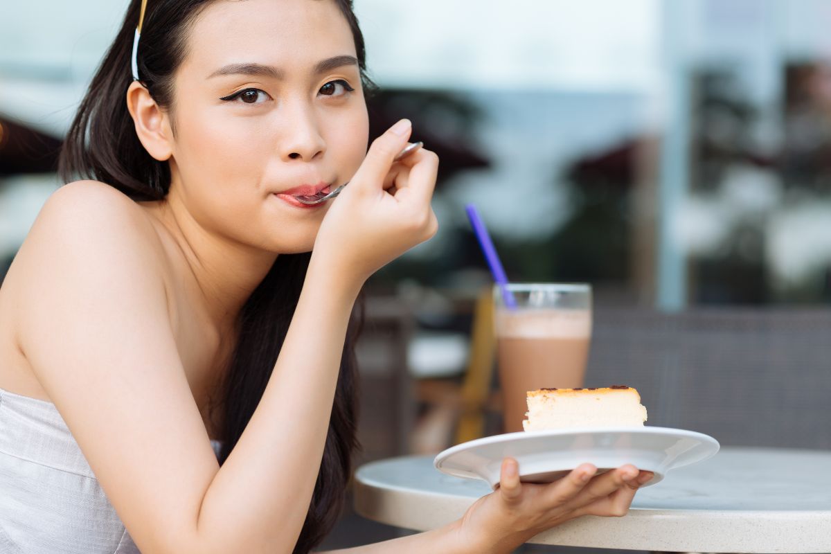 Wanita sedang memakan kue manis