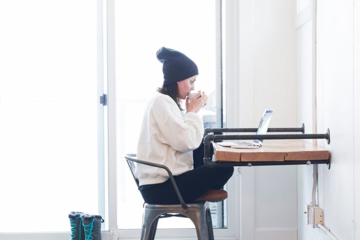 Perempuan duduk di depan laptop