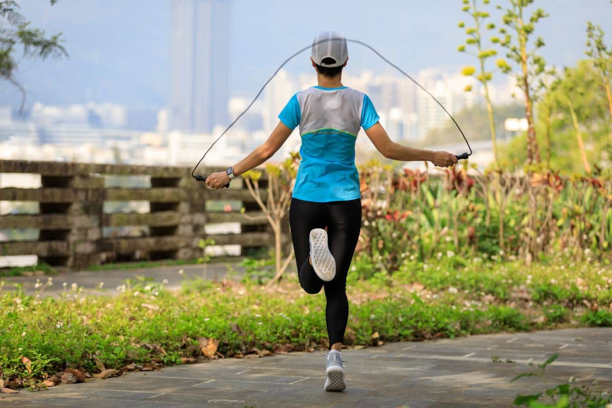 Seorang wanita melakukan skipping di taman