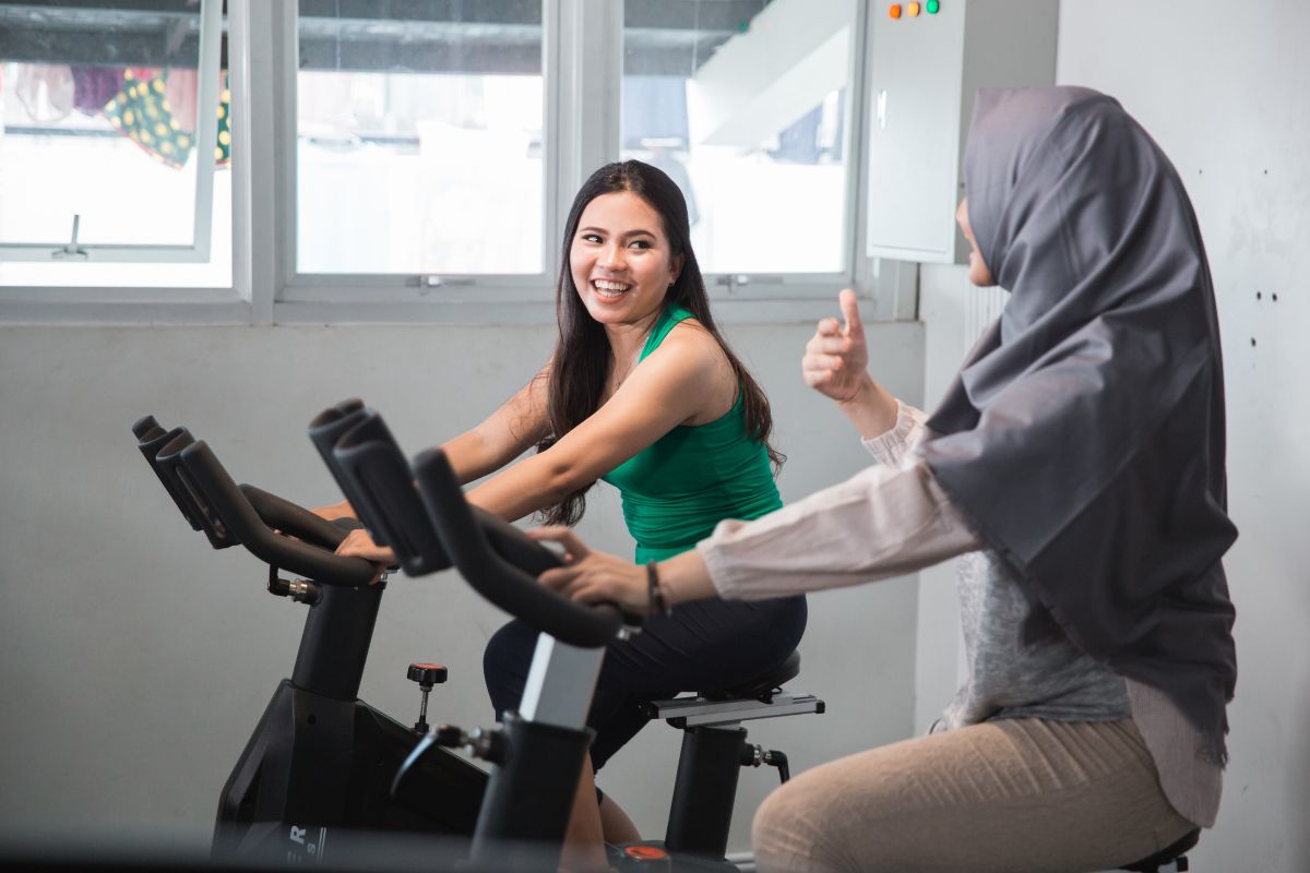 Dua orang wanita sedang berolahraga di gym