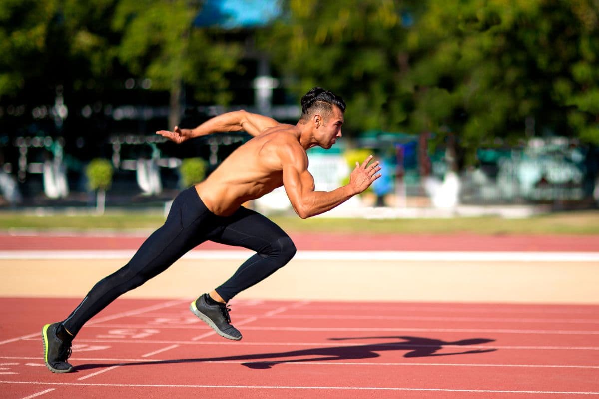 Pria sedang melakukan sprint di lapangan