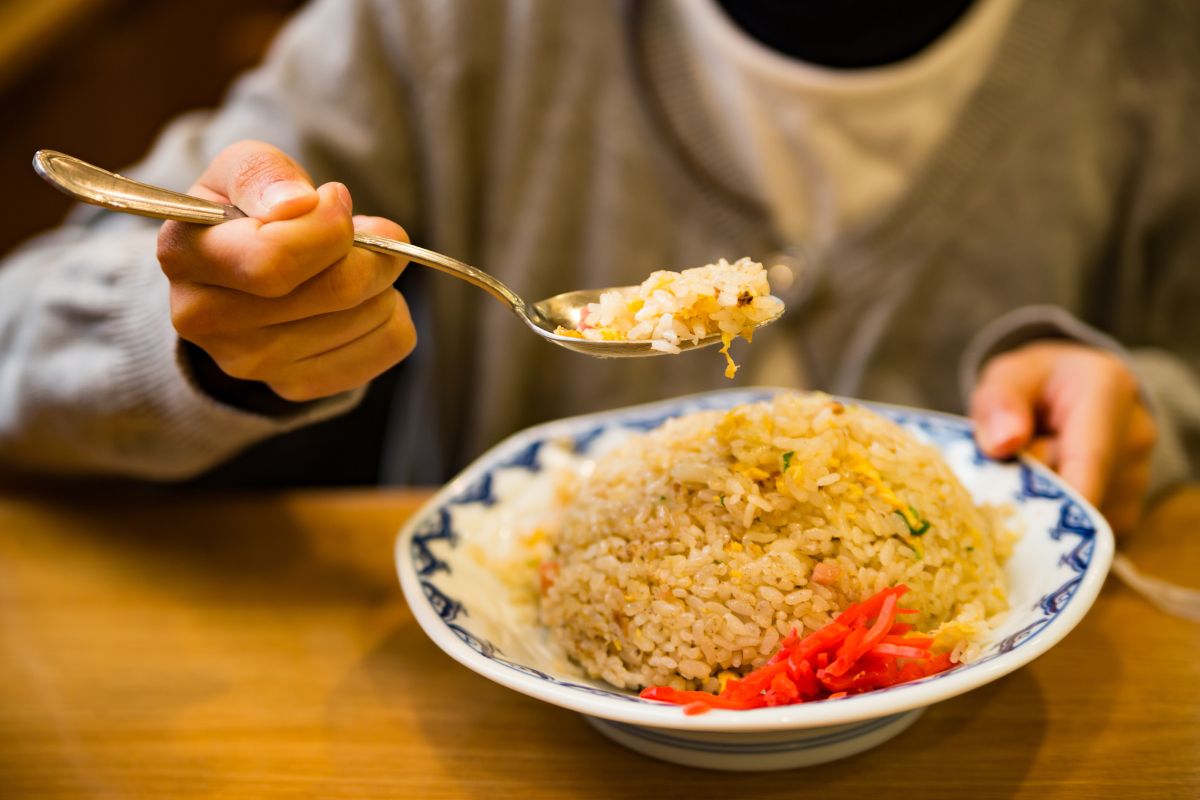 Seseorang sedang makan nasi goreng