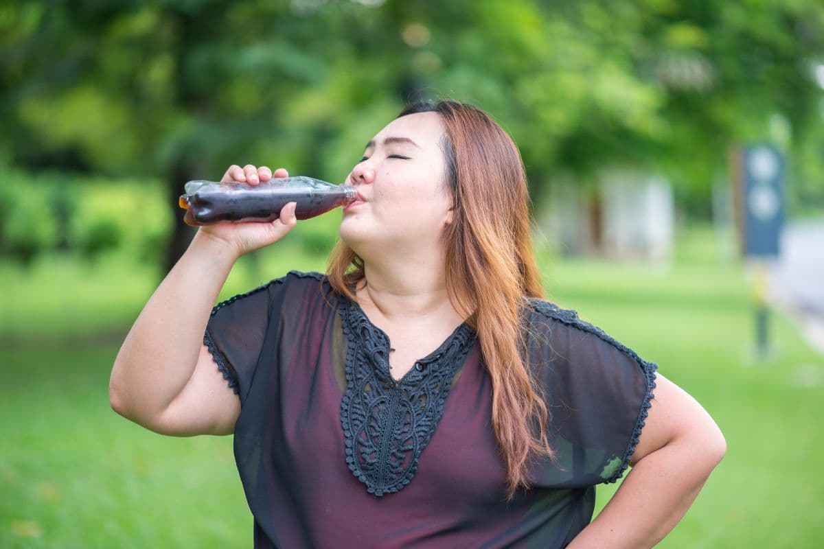 Wanita sedang meminum soda