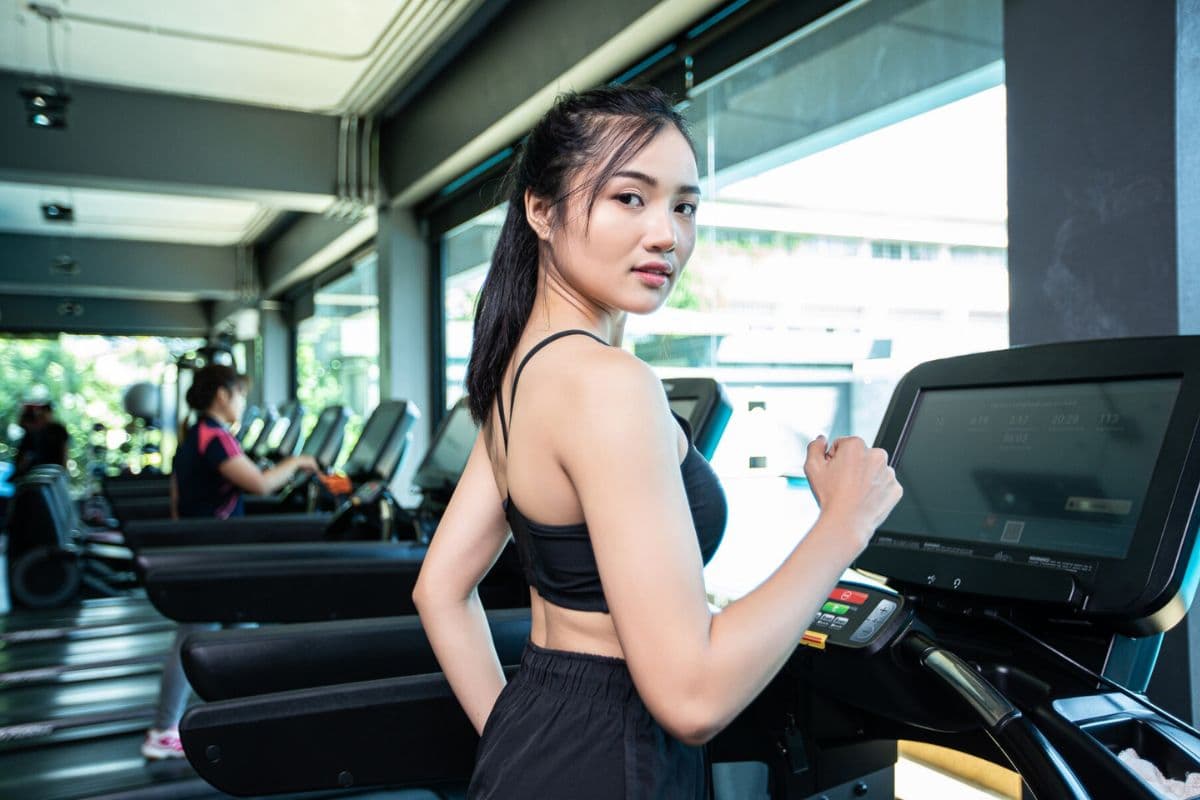 Wanita sedang olahraga dengan alat gym untuk pemula treadmill