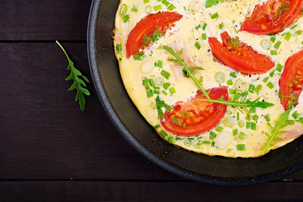 Omelet dengan potongan tomat merah