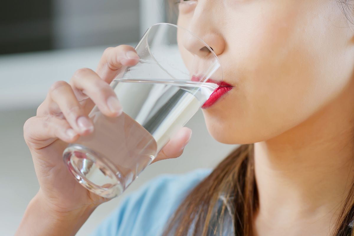 Seorang wanita sedang minum air putih