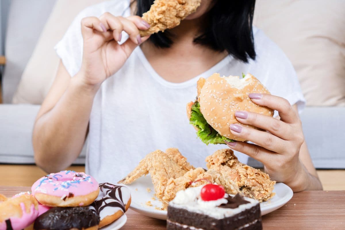 Seorang wanita sedang memakan banyak makanan