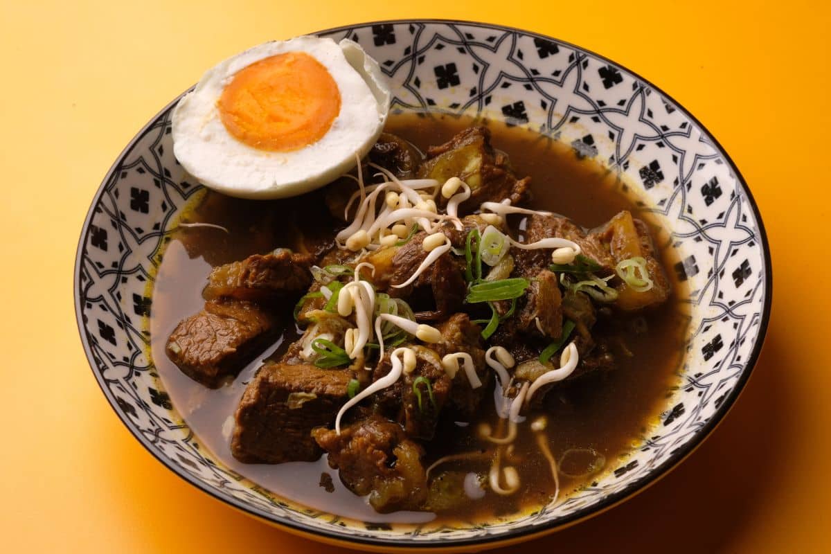 Semangkuk rawon dengan telur asin