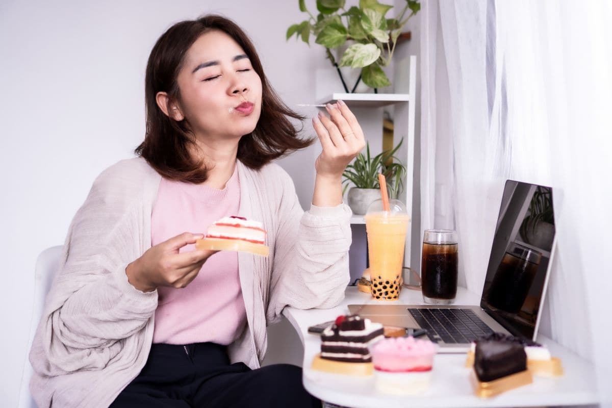 Wanita sedang memakan makanan manis