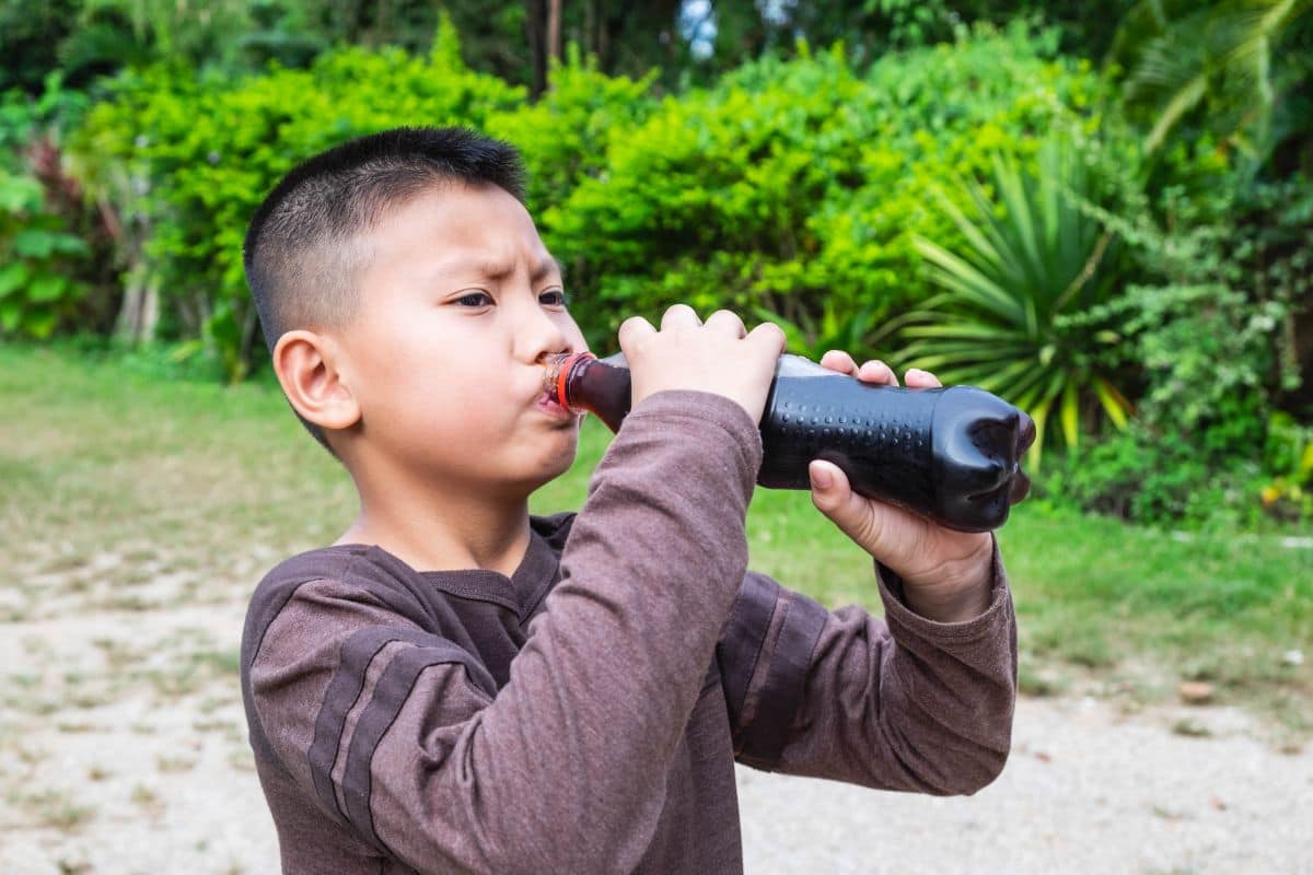 Anak kecil sedang minum soda