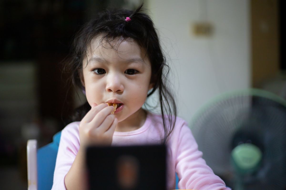 Anak makan sambil bermain ponsel