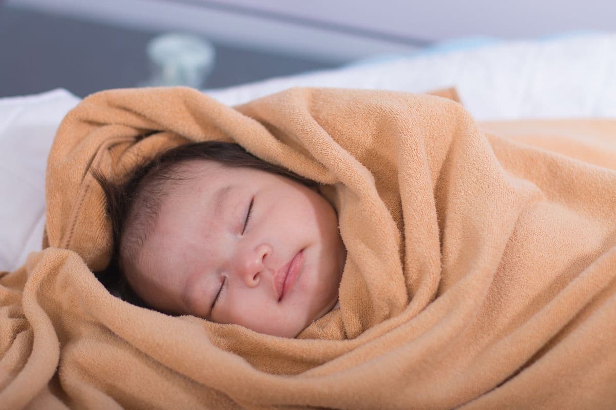 Bayi tidur dengan menggunakan selimut