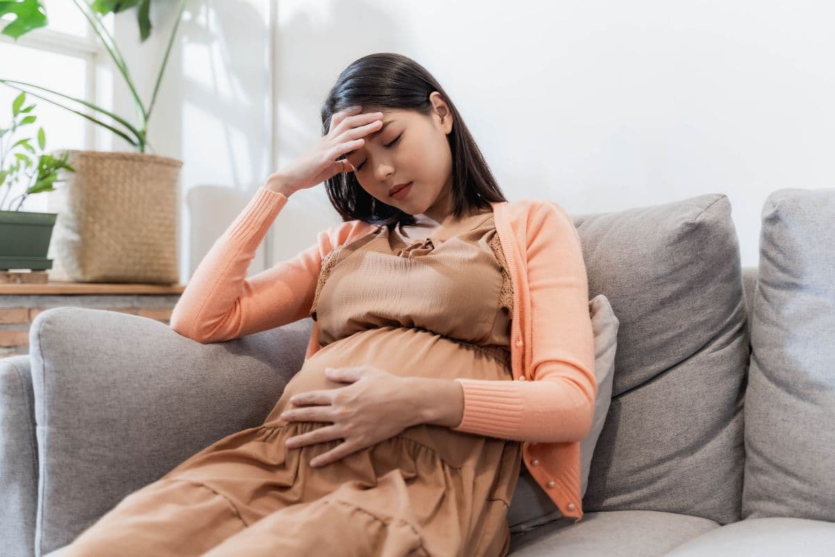 Wanita hamil sedang duduk di sofa