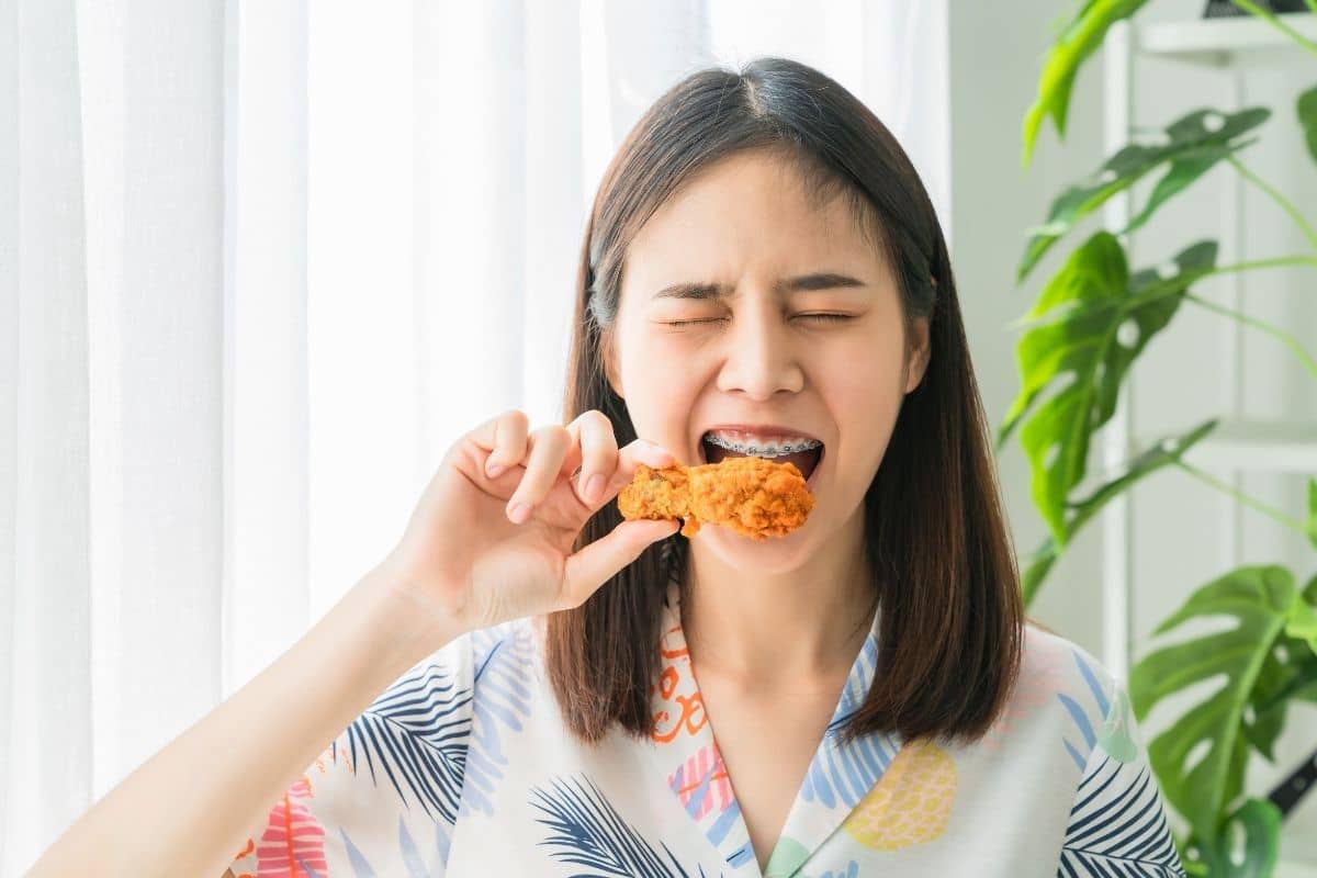 Seorang wanita sedang makan ayam