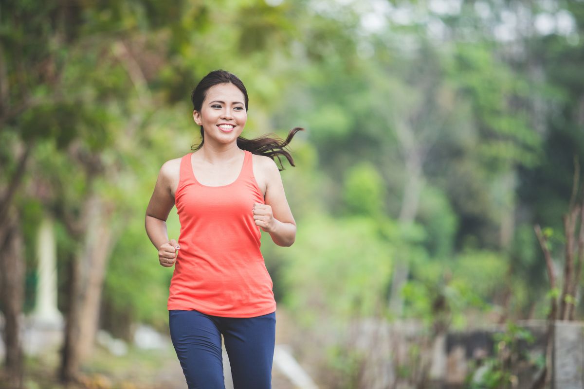 wanita muda sedang jogging di taman