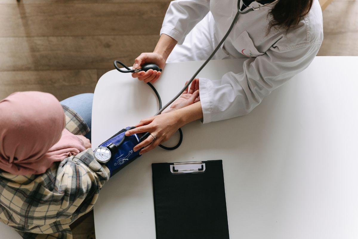 Dokter sedang memeriksa tekanan darah pasien