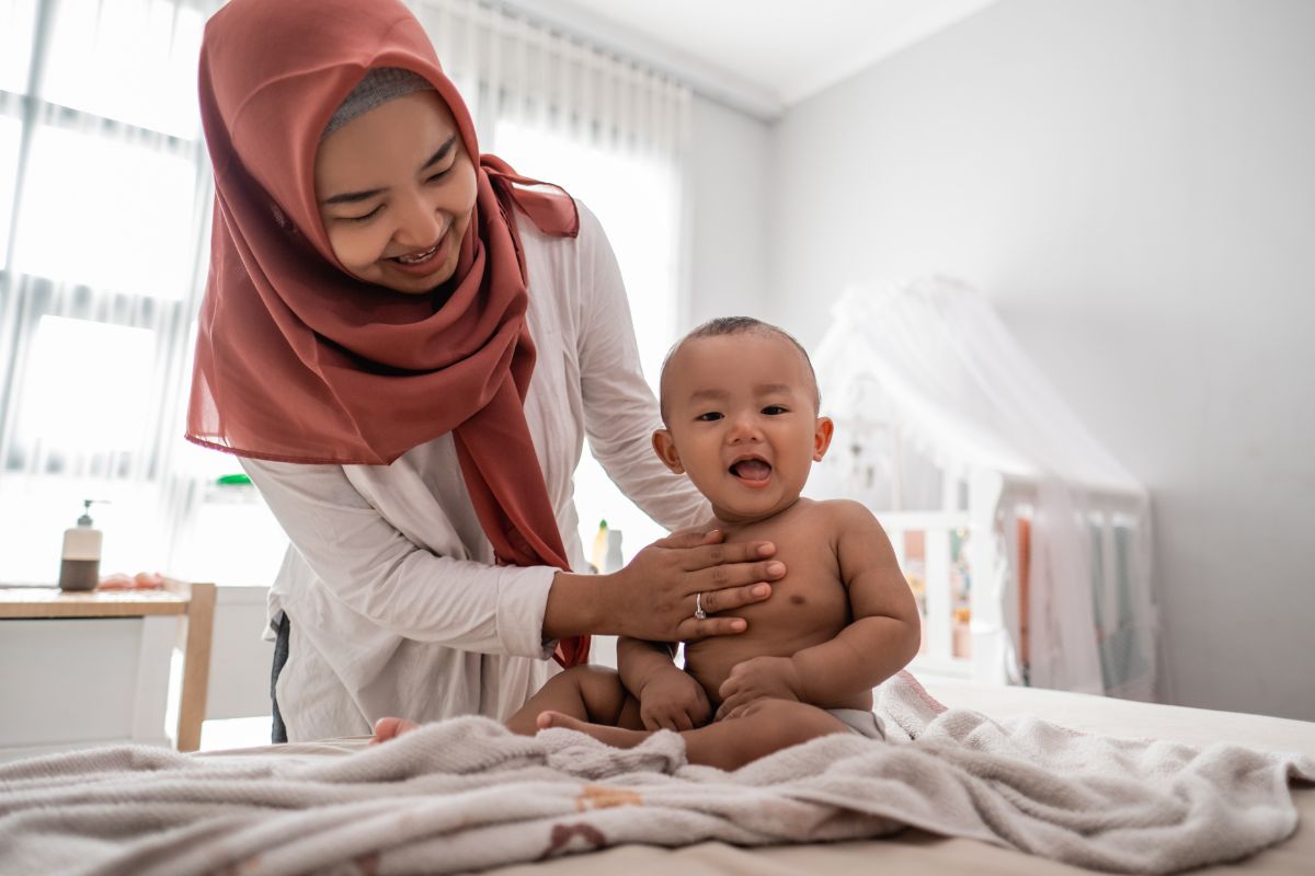 Ibu memijat dada bayi untuk menghilangkan batuk