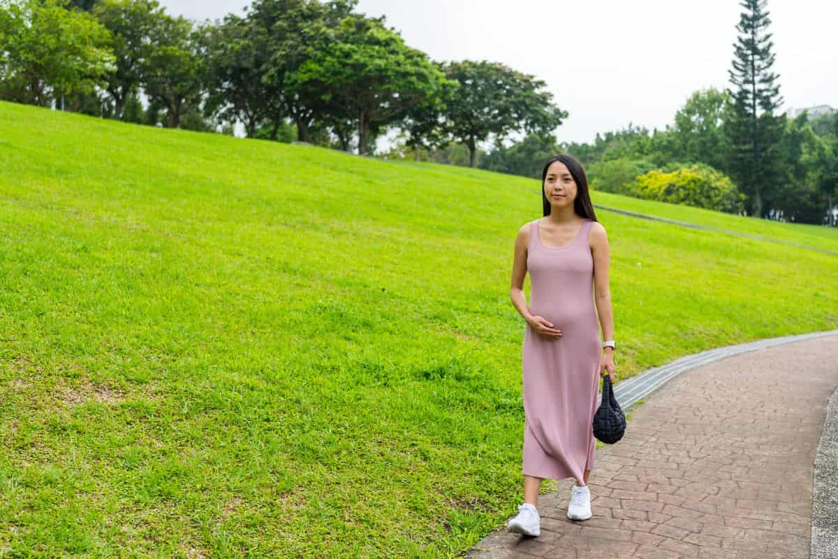 Wanita hamil sedang berjalan kaki di taman