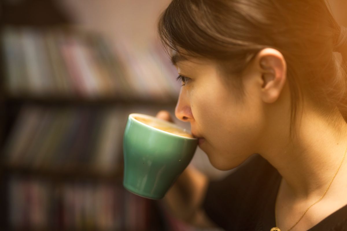 Seorang wanita sedang meminum kopi