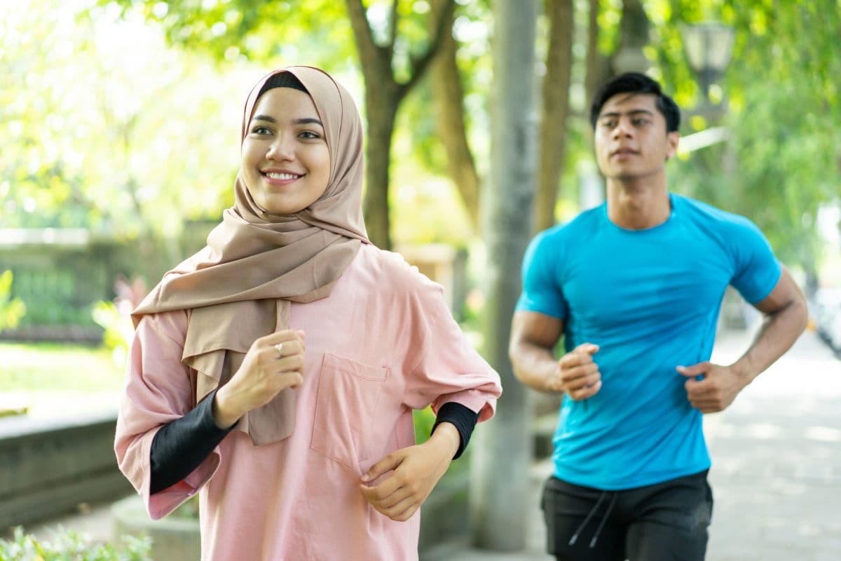 Pria dan wanita muda sedang jogging di taman