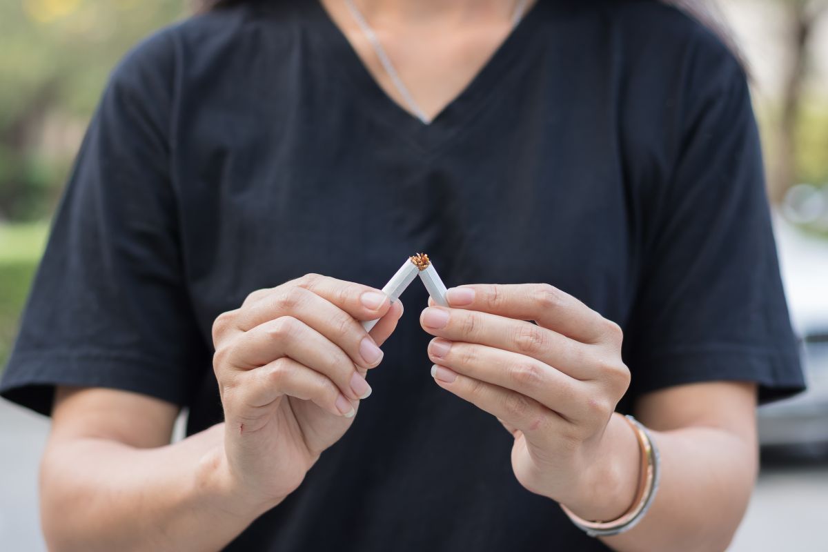 Seseorang sedang mematahkan rokok