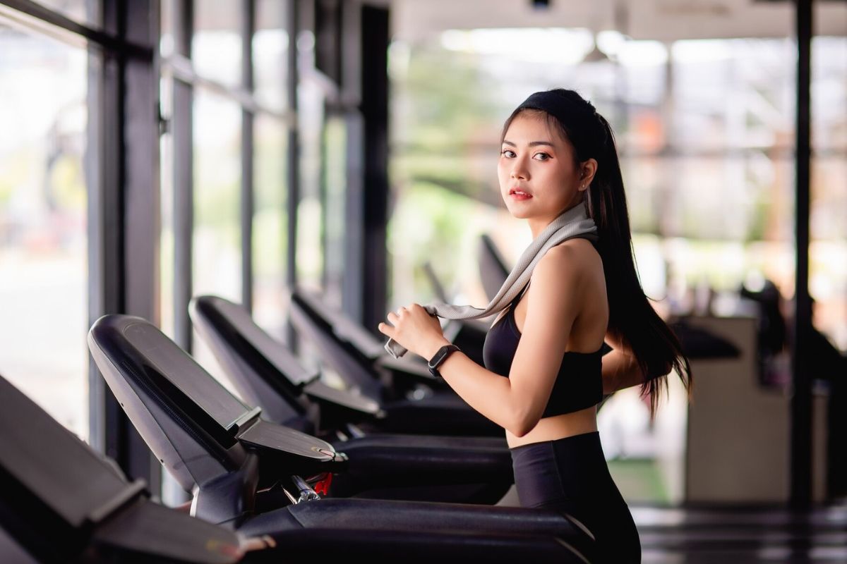 Wanita sedang menggunakan alat gym