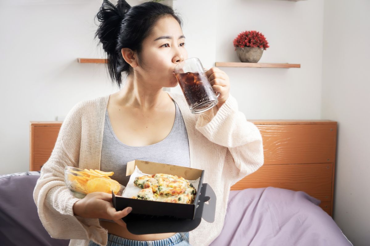 Wanita sedang mengonsumsi makanan dan minuman yang tidak bernutrisi