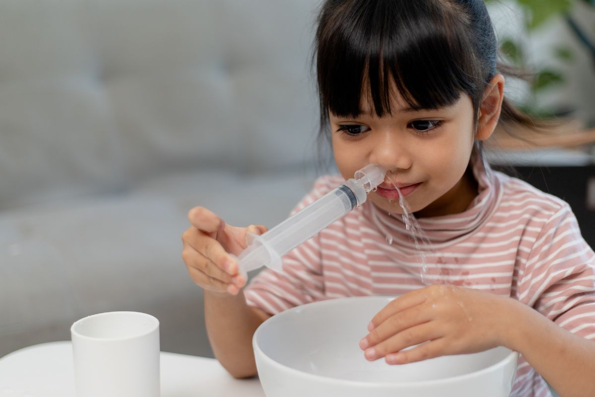 Anak membersihkan hidung tersumbat dengan air garam