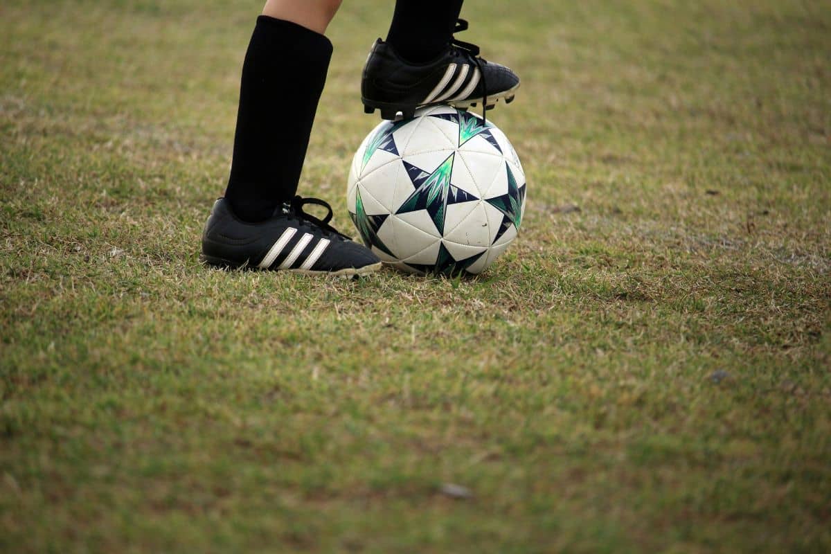 anak yang sedang menginjak bola