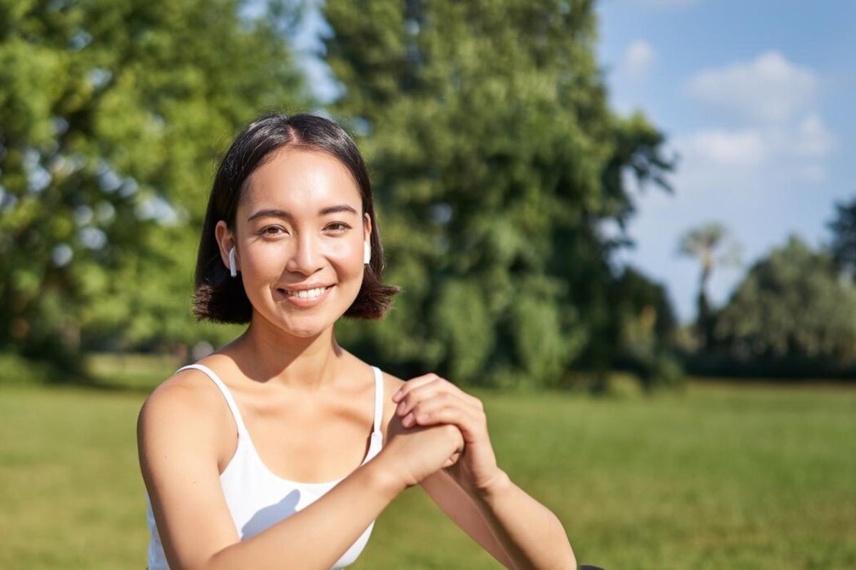 Seorang wanita tersenyum di area outdoor