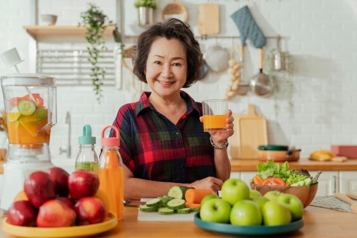 Perempuan memegang gelas dikelilingi makanan segar