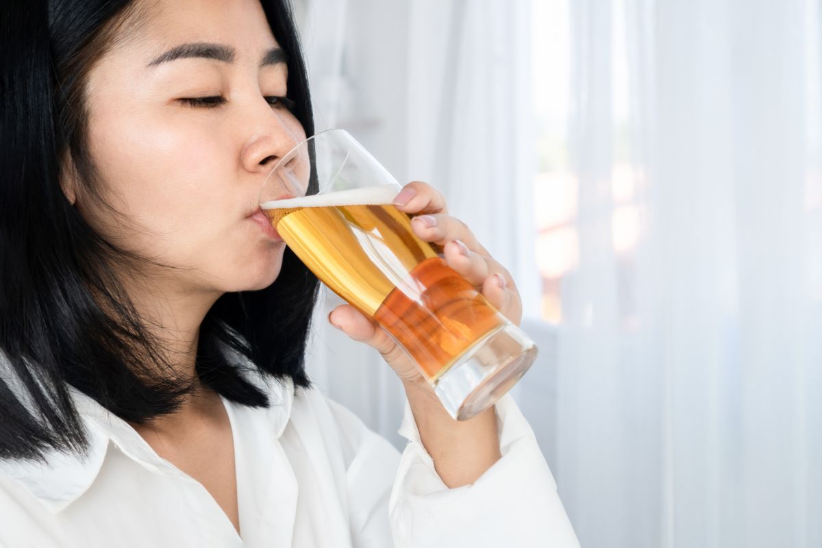 Seorang wanita sedang meminum minuman beralkohol