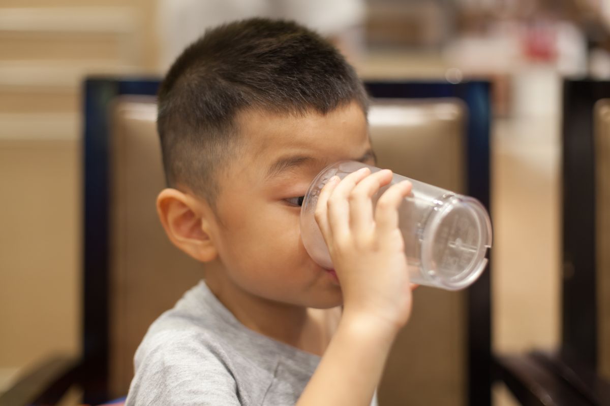 Anak laki-laki sedang minum air