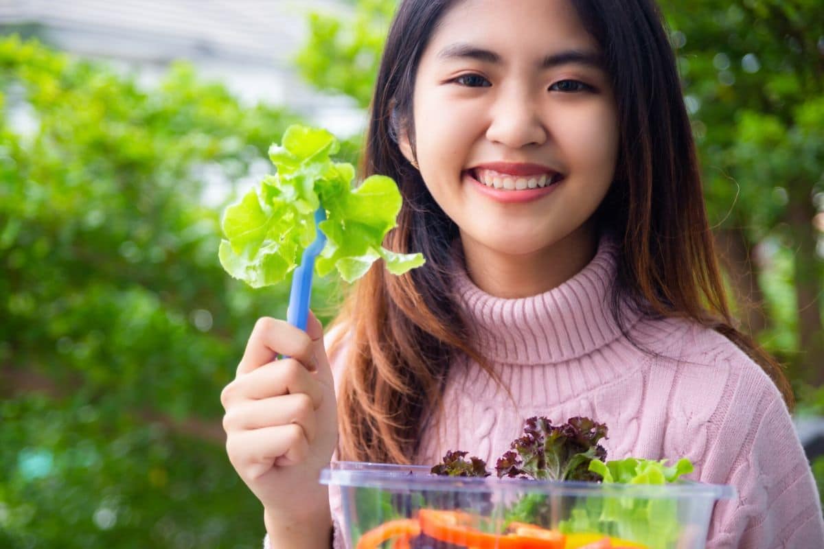 Wanita memakan sayur untuk menurunkan gula darah