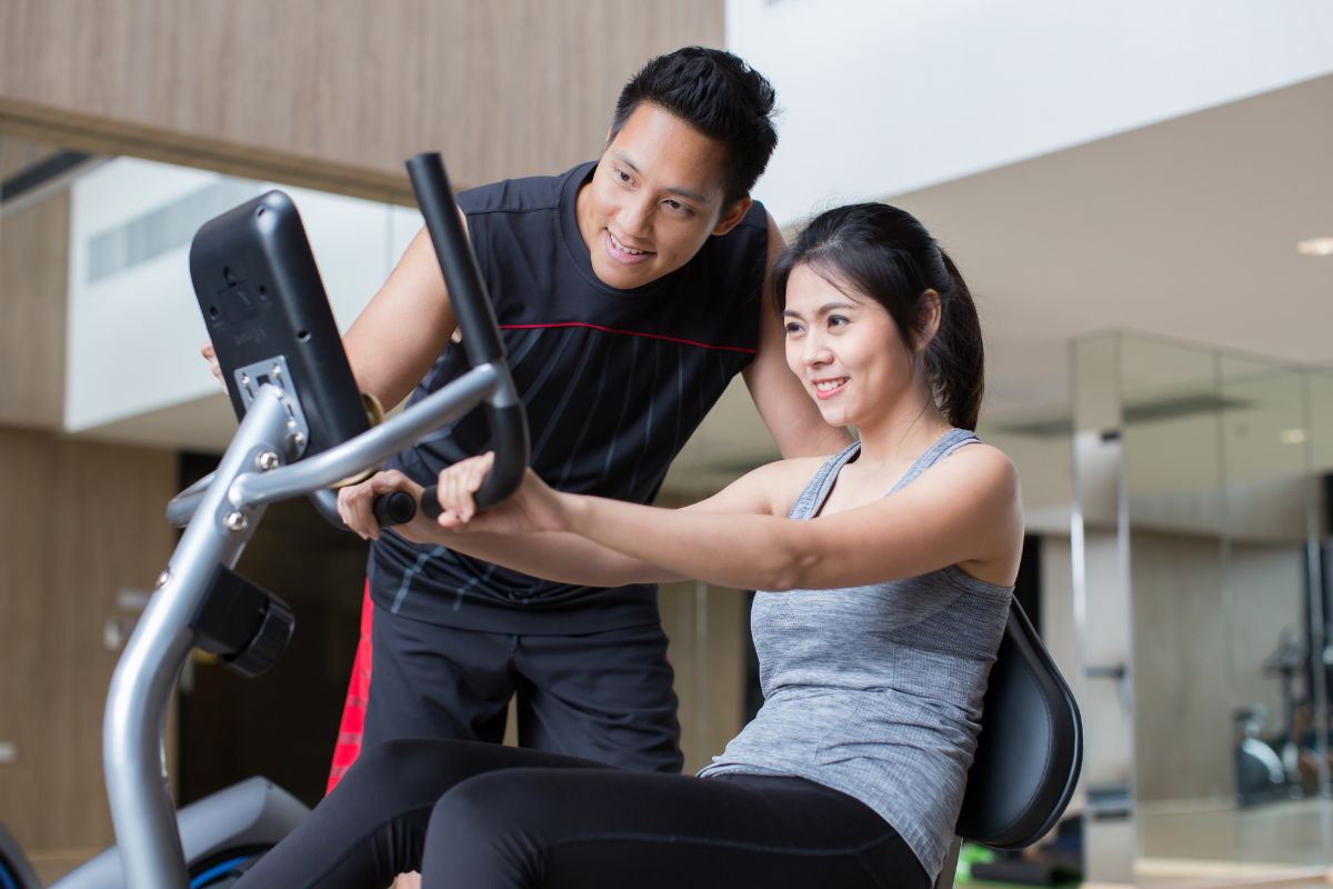 Seorang pria dan wanita sedang berolahraga di gym