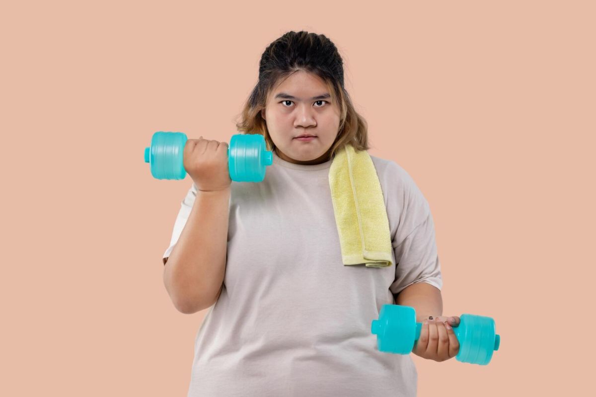 Wanita dengan obesitas sedang berolahraga dengan dumbbell