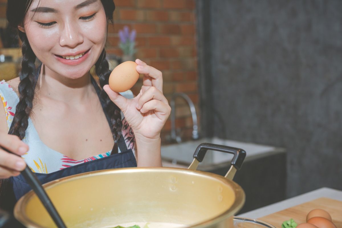 Wanita sedang memasak telur