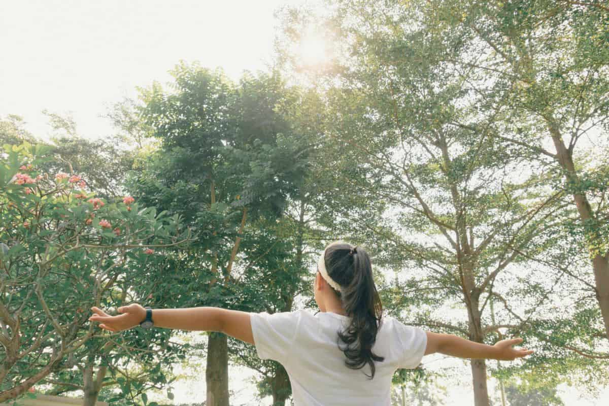 orang yang merentangkan tangan di luar ruangan