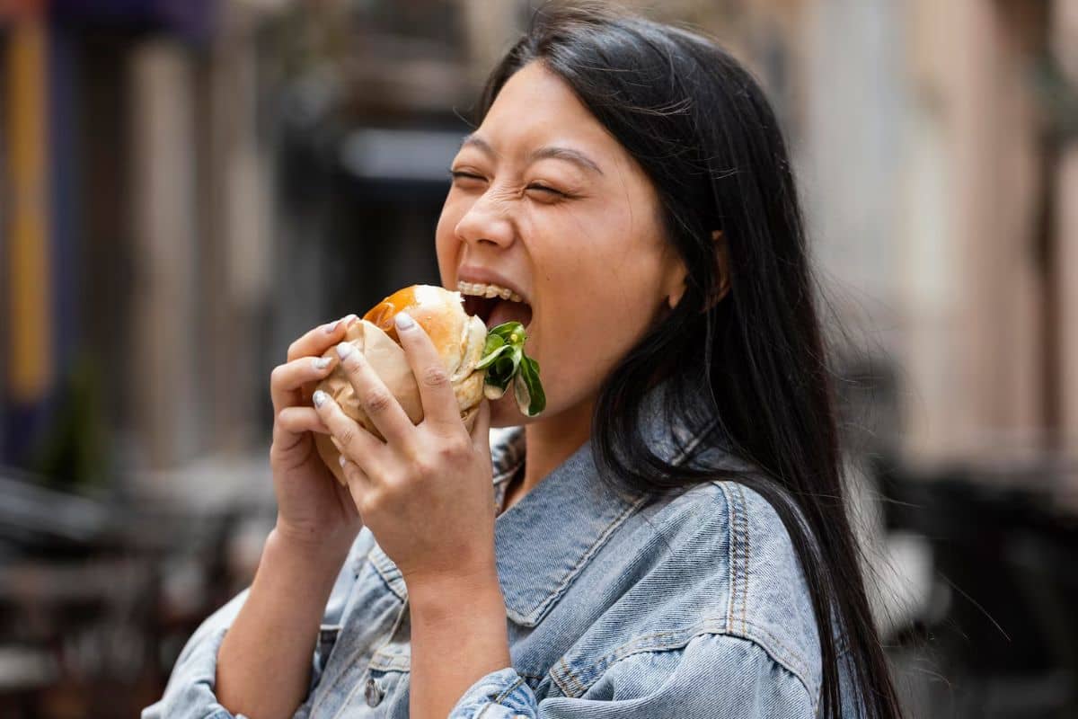 Wanita sedang memakan burger