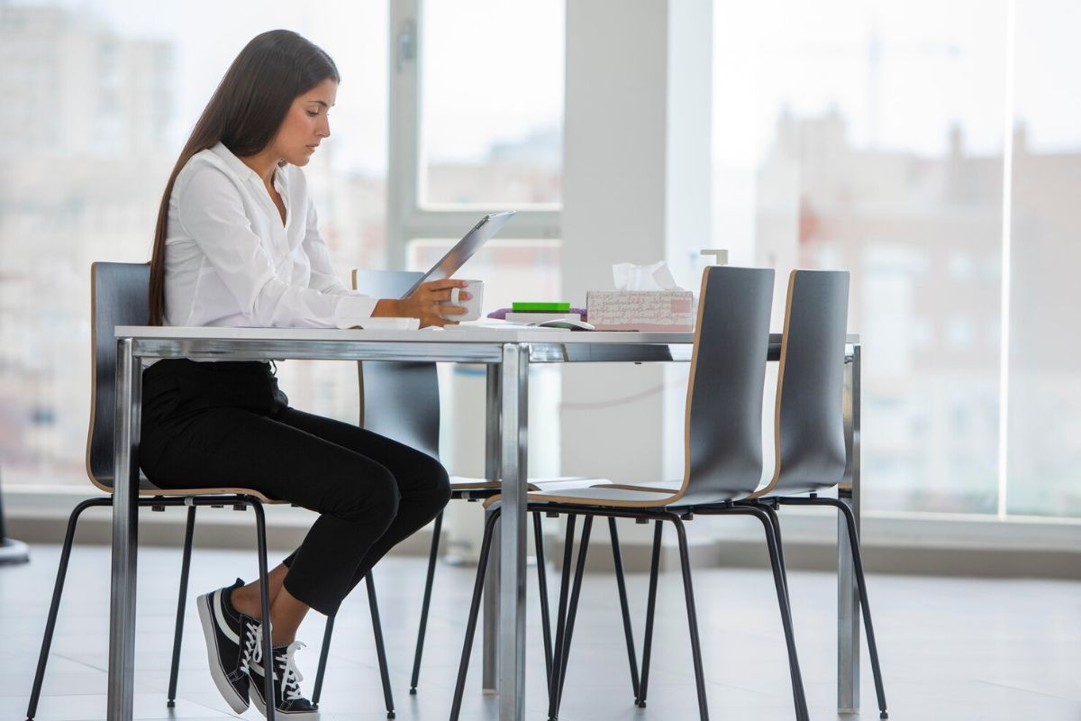 Seorang wanita duduk dengan tegak di kantor