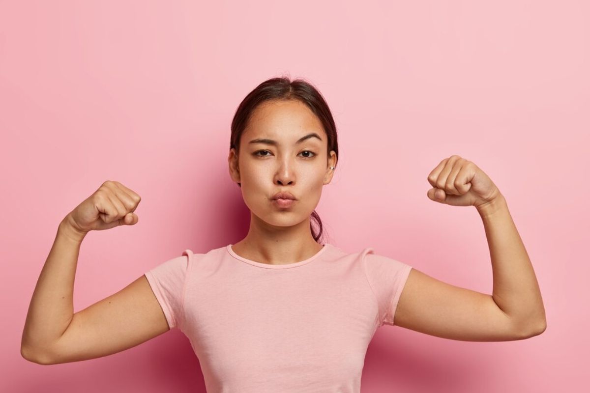 Wanita dengan pose tangan memamerkan otot lengan