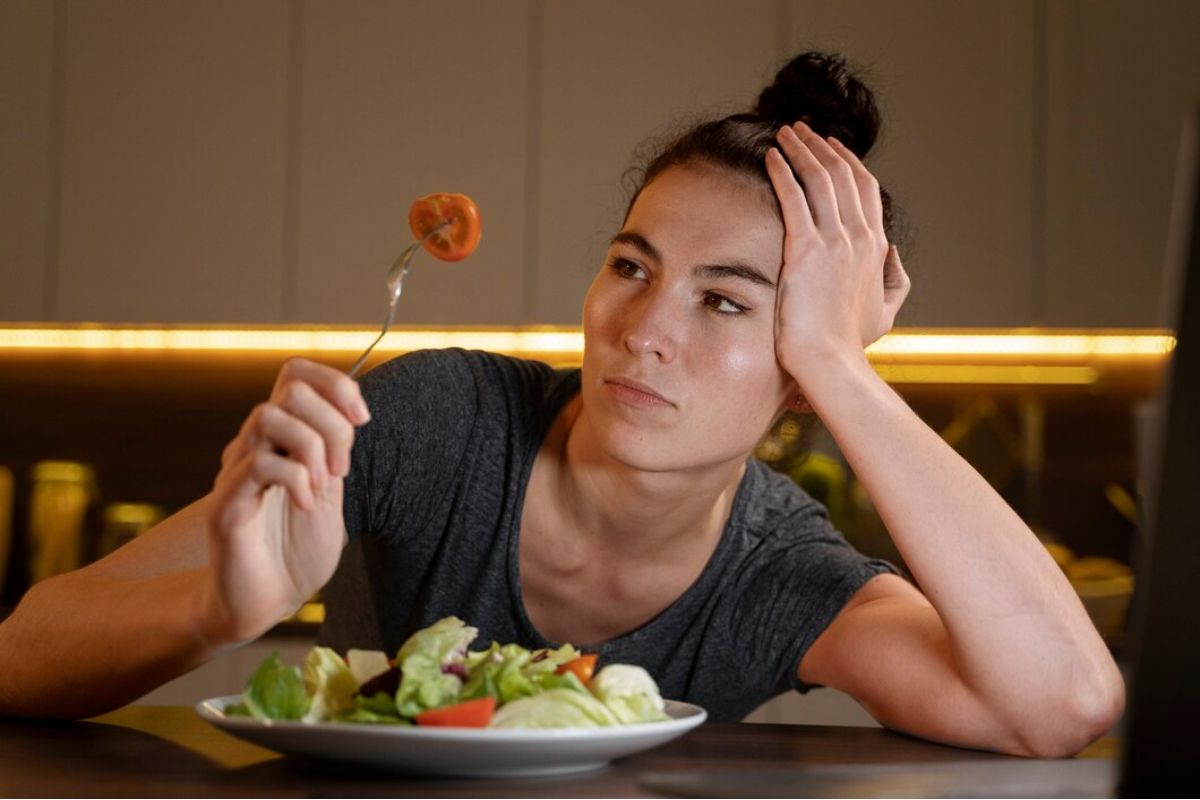 Perempuan memandangi makanannya