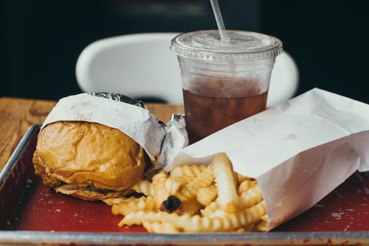 Burger di sebelah kentang goreng dan cola