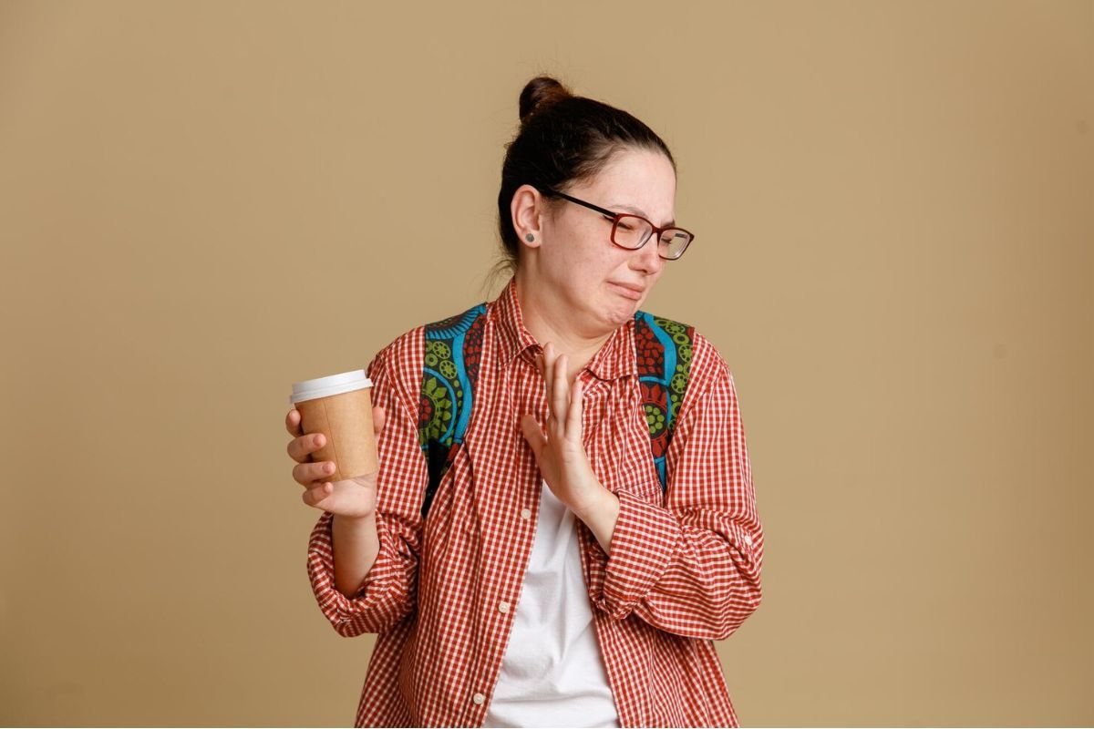 Perempuan memegang cup kopi