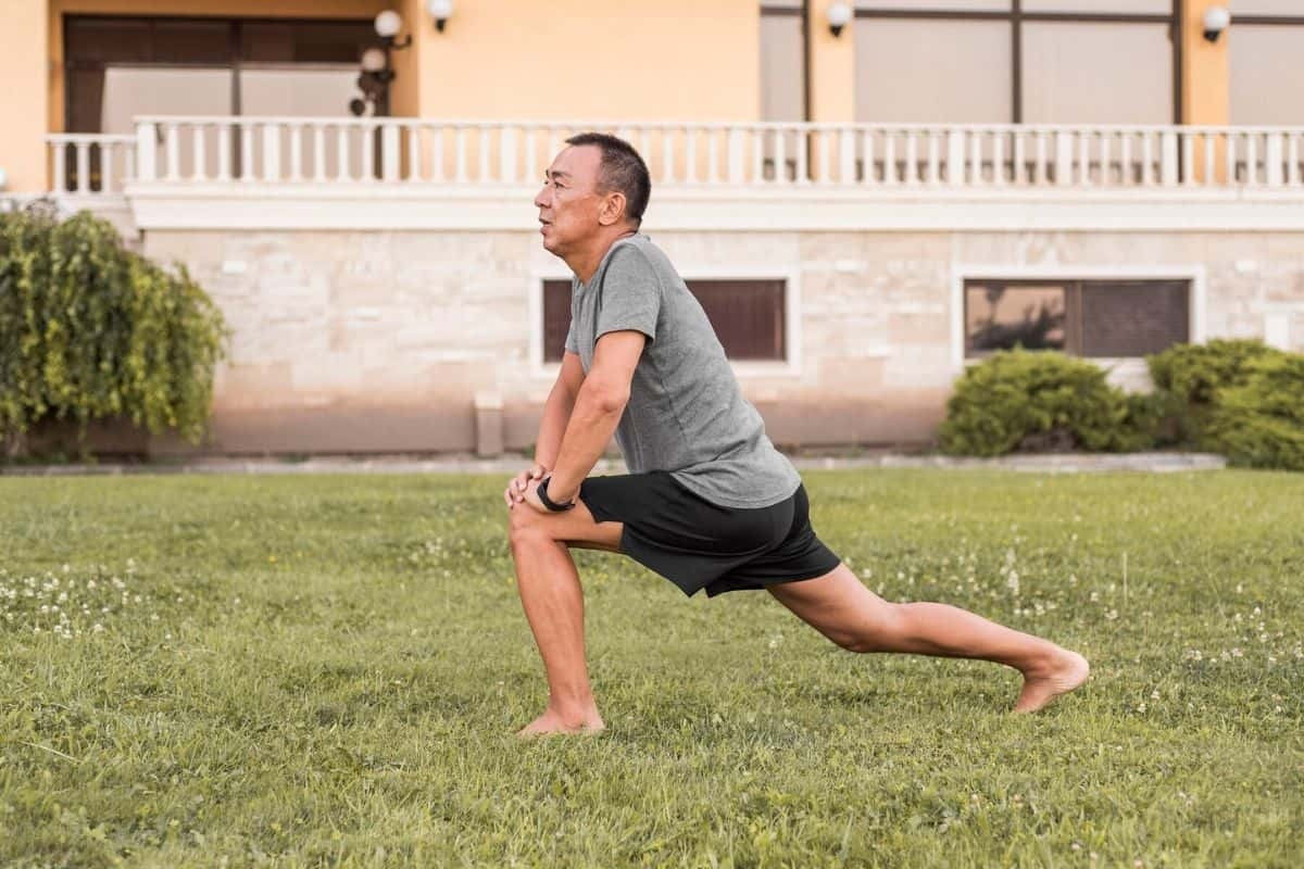 Seorang pria melakukan lunge di rumput